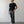 Load image into Gallery viewer, Man wearing a black t-shirt and gray pants standing against a plain white wall.
