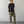 Load image into Gallery viewer, Man wearing a black t-shirt and olive green pants standing against a plain white wall.
