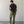 Load image into Gallery viewer, Man wearing a black t-shirt and green cargo pants standing against a plain white wall.
