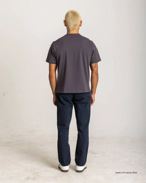 Back view of a short man wearing Navy Straight Chino Pants with a dark grey T-shirt and white sneakers, highlighting the back pockets, straight fit, and shorter inseam.