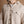 Load image into Gallery viewer, A close-up of a short male model wearing a tan flannel button-up shirt, highlighting the textured fabric, brown buttons, and chest pockets.
