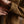 Load image into Gallery viewer, A close-up lifestyle shot of a person's hand adjusting the cuff of a brown canvas utility jacket, wearing a silver chain link bracelet on the wrist.

