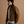 Load image into Gallery viewer, A 5'8" man wearing a brown canvas utility jacket with a dark collar, layered over a white t-shirt and blue jeans, standing against a solid warm brown studio background.
