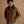 Load image into Gallery viewer, A man wearing a brown utility jacket with a dark brown corduroy collar, paired with light blue jeans, standing against a solid warm brown studio background.
