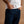 Load image into Gallery viewer, A close-up of a person wearing dark indigo blue jeans and a white t-shirt, with hands in the pockets, set against a solid warm brown background.
