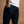 Load image into Gallery viewer, A close-up back view of a person wearing dark indigo denim jeans with a white t-shirt, standing against a solid warm beige background.
