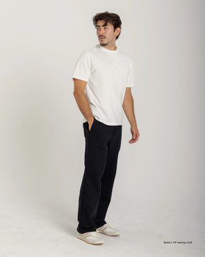Short Man wearing a white t-shirt and black pants on a plain background