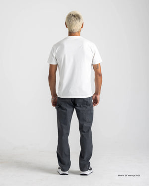 A short man shown from the back wearing Stone dark gray Loose Fit Workwear Pants with a white T-shirt and white sneakers, highlighting the back pockets and utility pocket.