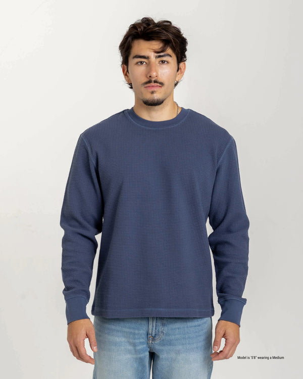 Short Man wearing a blue textured waffle shirt against a plain background