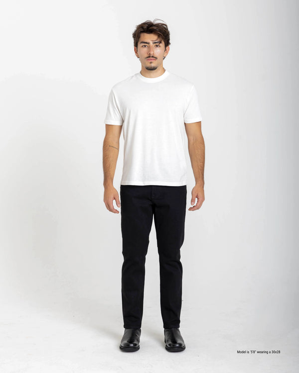 Shorter guy wearing a white t-shirt and black jeans on a white background
