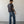 Load image into Gallery viewer, Man wearing a dark t-shirt and blue jeans standing against a plain white wall.
