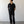 Load image into Gallery viewer, Man wearing a black outfit standing against a plain white wall.
