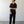 Load image into Gallery viewer, Man wearing a black outfit standing against a plain white wall.
