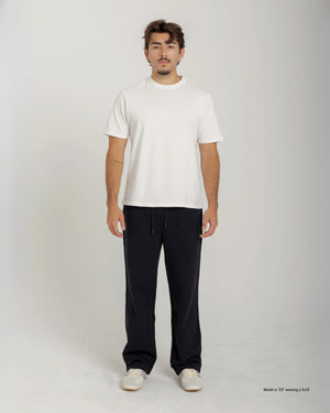 Short Man wearing a white t-shirt and black pants on a plain background