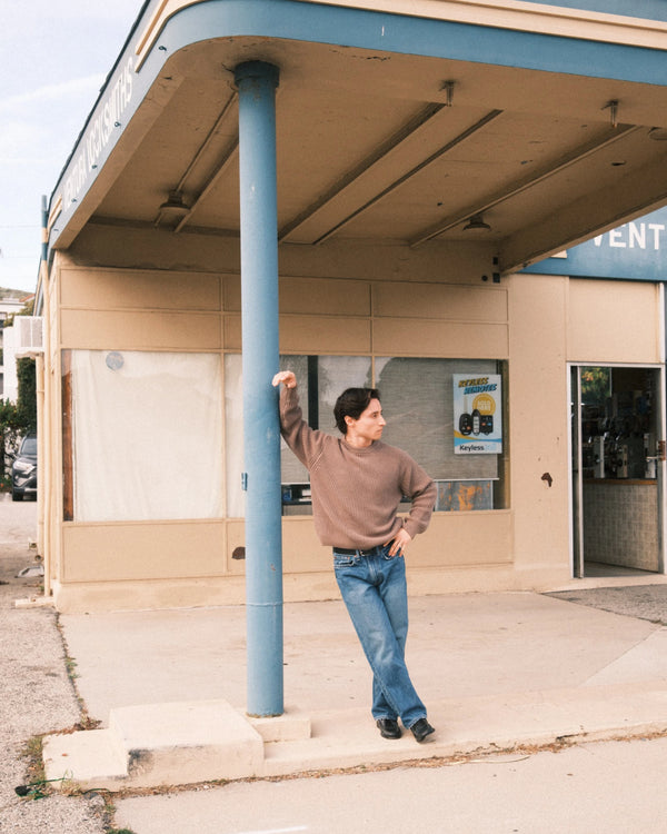 Short Man standing under a blue overhang in front of a building