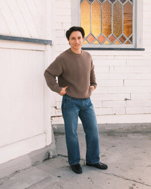 Man wearing a black t-shirt and black pants on a plain background