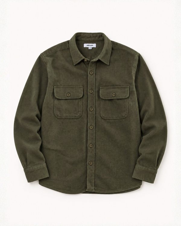 An olive green flannel button-up shirt jacket with two buttoned chest flap pockets, laid flat against a light off-white background.