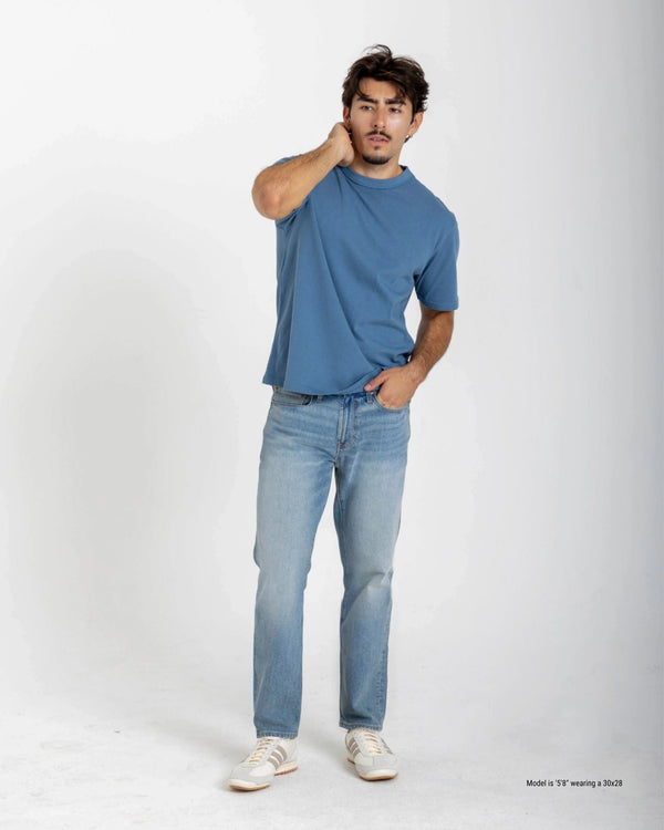 Short Man wearing a blue t-shirt and light blue jeans on a white background