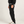 Load image into Gallery viewer, Side view of black jogger sweatpants for shorter men, showing the tapered fit from hip to cuffed ankle with white sneakers
