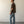 Load image into Gallery viewer, Shorter Man wearing a brown shirt and blue jeans standing against a plain white wall.
