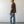 Load image into Gallery viewer, Man wearing a brown shirt and blue jeans standing against a white wall.
