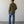 Load image into Gallery viewer, Man wearing a green jacket and blue jeans standing against a plain white wall.

