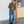 Load image into Gallery viewer, Man wearing a green shirt and blue jeans standing against a white wall.
