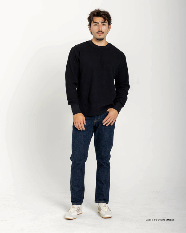 Short Man wearing a black sweater and blue jeans on a white background