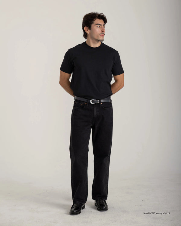 Man wearing a black t-shirt and black pants on a plain background