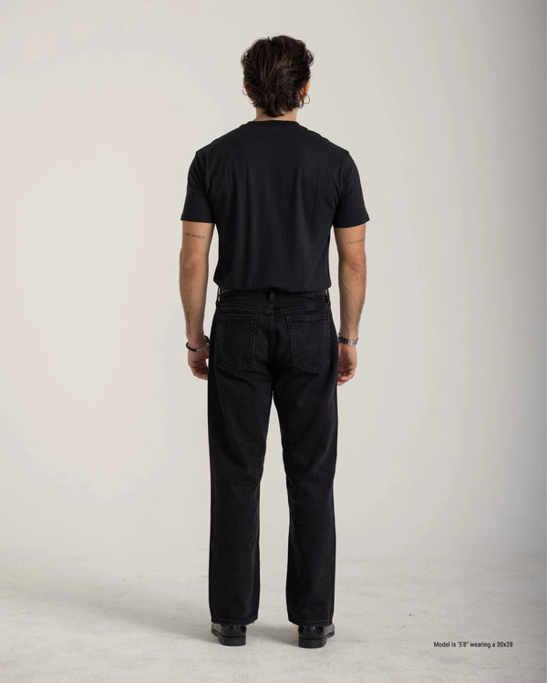 Person wearing a black t-shirt and black pants on a plain background