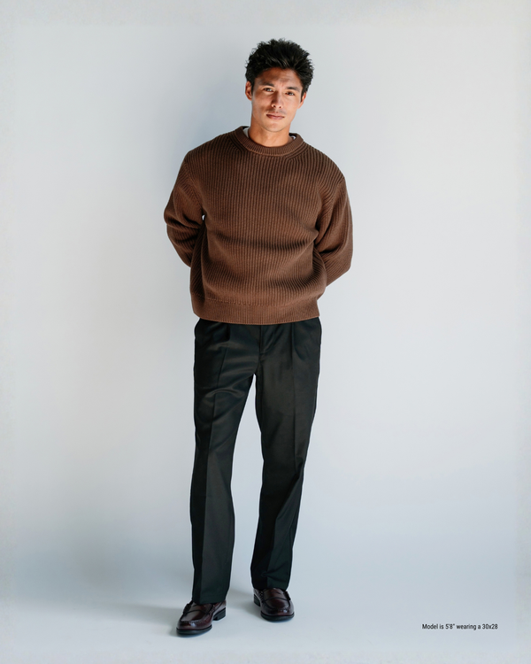 5'8" man wearing black loose-fit pleated menswear trousers in a 30x28 with a brown crewneck sweater and loafers