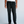 Load image into Gallery viewer, Front view of black loose-fit pleated trousers from waist to loafers, showing the relaxed straight leg on a shorter man
