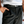 Load image into Gallery viewer, Close-up of the front pleat and waistband on black loose menswear trousers worn with a black leather belt
