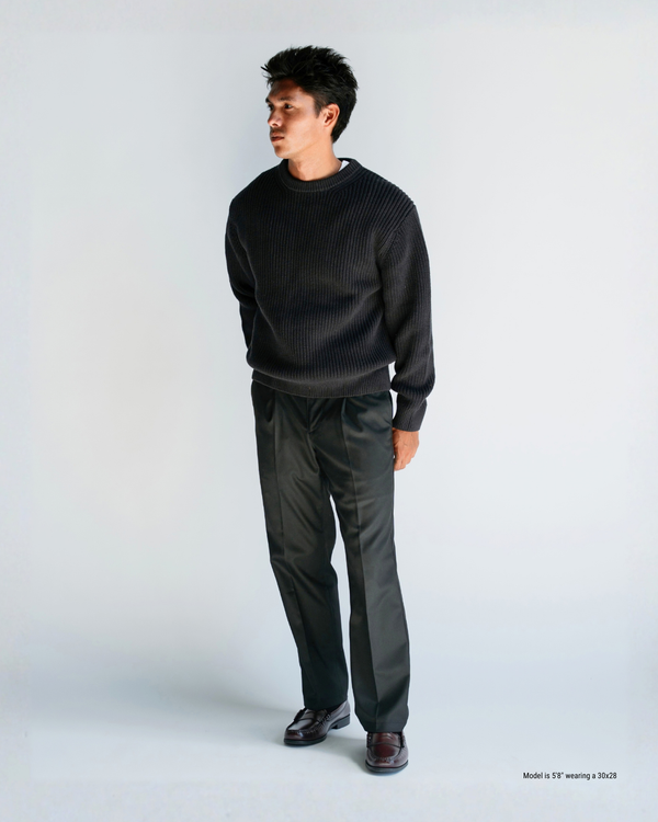 5'8" man wearing charcoal loose pleated trousers in a 30x28 with a black textured sweater and burgundy loafers