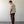 Load image into Gallery viewer, Man wearing a beige shirt and brown pants standing against a white wall.

