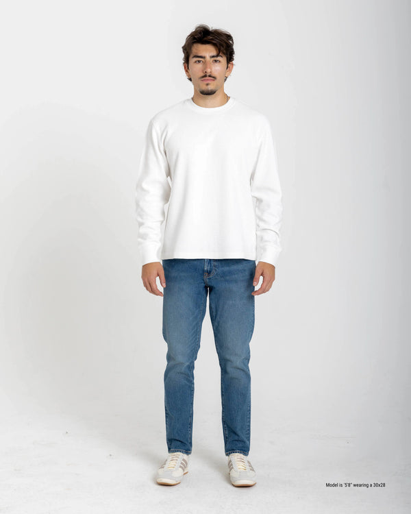 Short Man wearing a white sweater and blue jeans on a white background