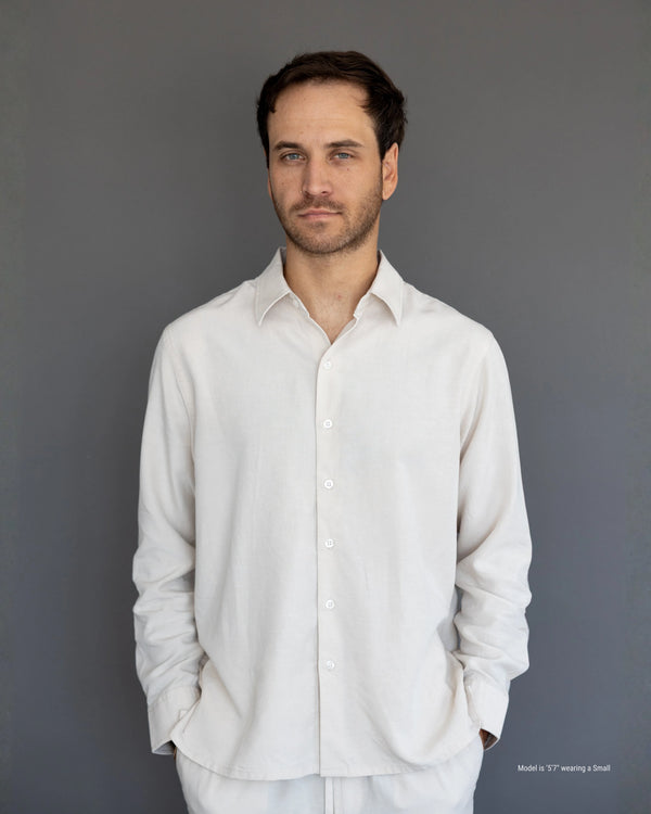 Man wearing a light gray shirt against a plain background