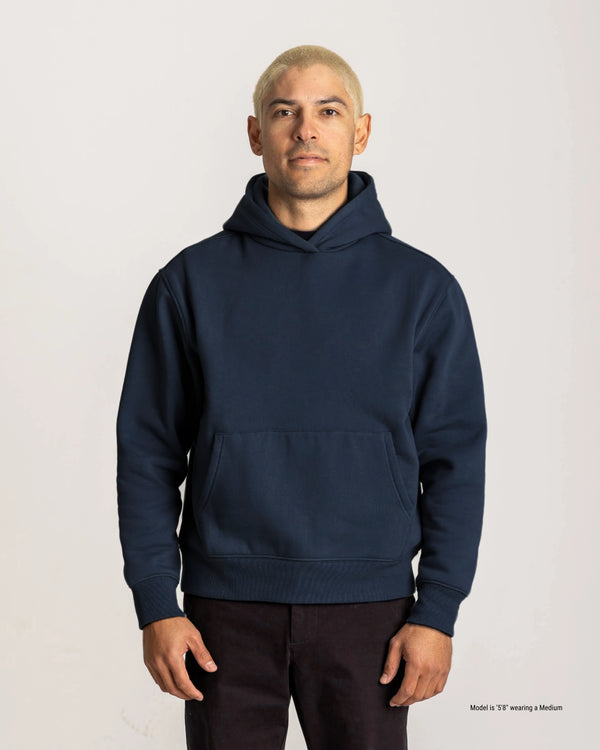 Man wearing a navy blue hoodie on a light gray background