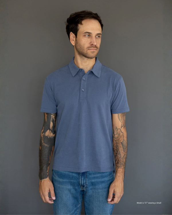 5'7" Man wearing a blue polo shirt against a gray background