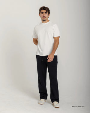 Short Man wearing a white t-shirt and black pants on a plain background