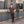 Load image into Gallery viewer, 5'4" Man standing against a gray wall with a door in an urban setting
