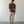 Load image into Gallery viewer, Man wearing a brown shirt and beige pants standing against a white wall.
