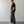 Load image into Gallery viewer, Man wearing a black t-shirt and dark pants standing against a plain white wall.
