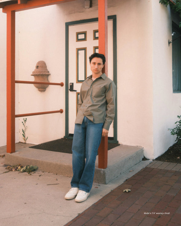 Person standing on a porch with a white door and red railing