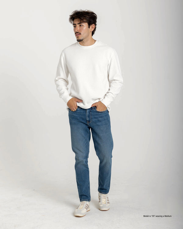 Short Man wearing a white sweater and blue jeans on a white background