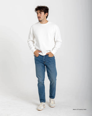 Short Man wearing a white sweater and blue jeans on a white background