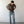 Load image into Gallery viewer, Man wearing a brown shirt and blue jeans against a white wall.

