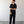 Load image into Gallery viewer, Man wearing a black outfit standing against a plain white wall.
