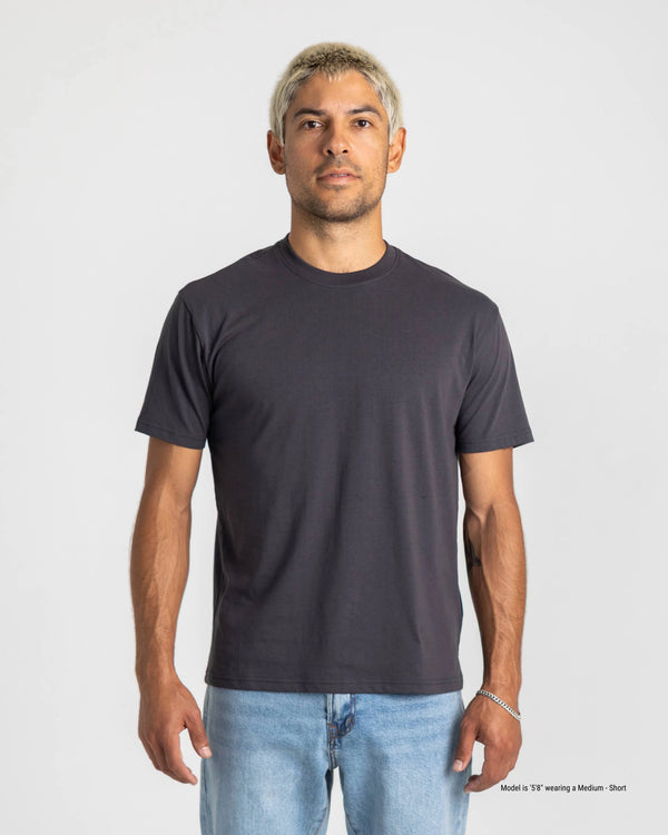 Man wearing a plain black t-shirt against a white background
