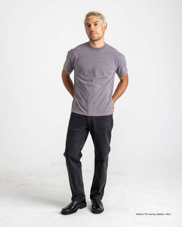 Man wearing a gray t-shirt and black pants on a white background